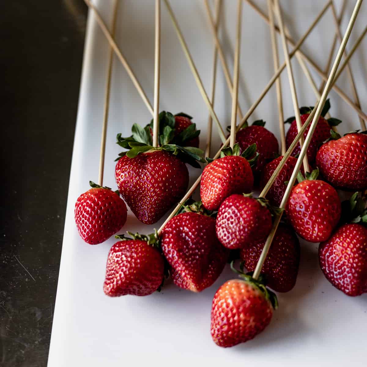 strawberries prepped for dipping into cooked syrup