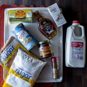 Overhead photo of biscuit dough rounds, melted butter, brown sugar, and pumpkin pie filling arranged on a baking tray.