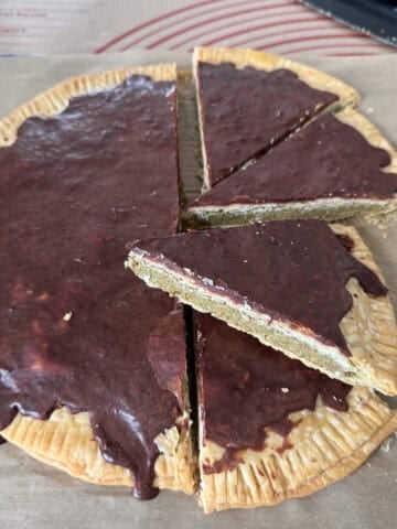Dubai chocolate poptarts made with pie crust, filled with pistachio cream and tahini, sliced into wedges and topped with a set chocolate glaze.