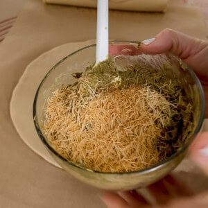 Pistachio cream mixed with tahini and toasted kataifi in a bowl for the filling of Dubai chocolate poptarts.