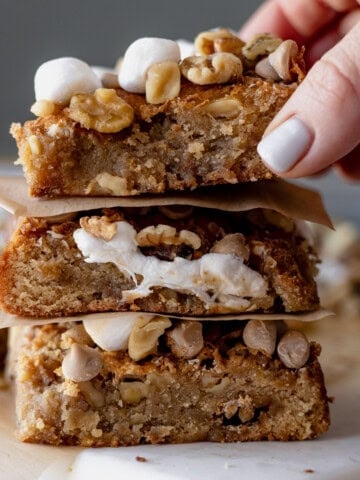 Stacked rocky road s’more blondies showing gooey marshmallow layers and dense blondie texture.
